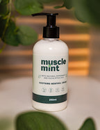 Bottle of Muscle Mint soothing menthol cream with a pump on a blurred natural background