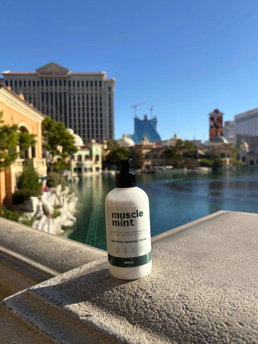 250ml bottle of Muscle Mint soothing menthol cream displayed beside the Bellagio fountains on the Las Vegas Strip