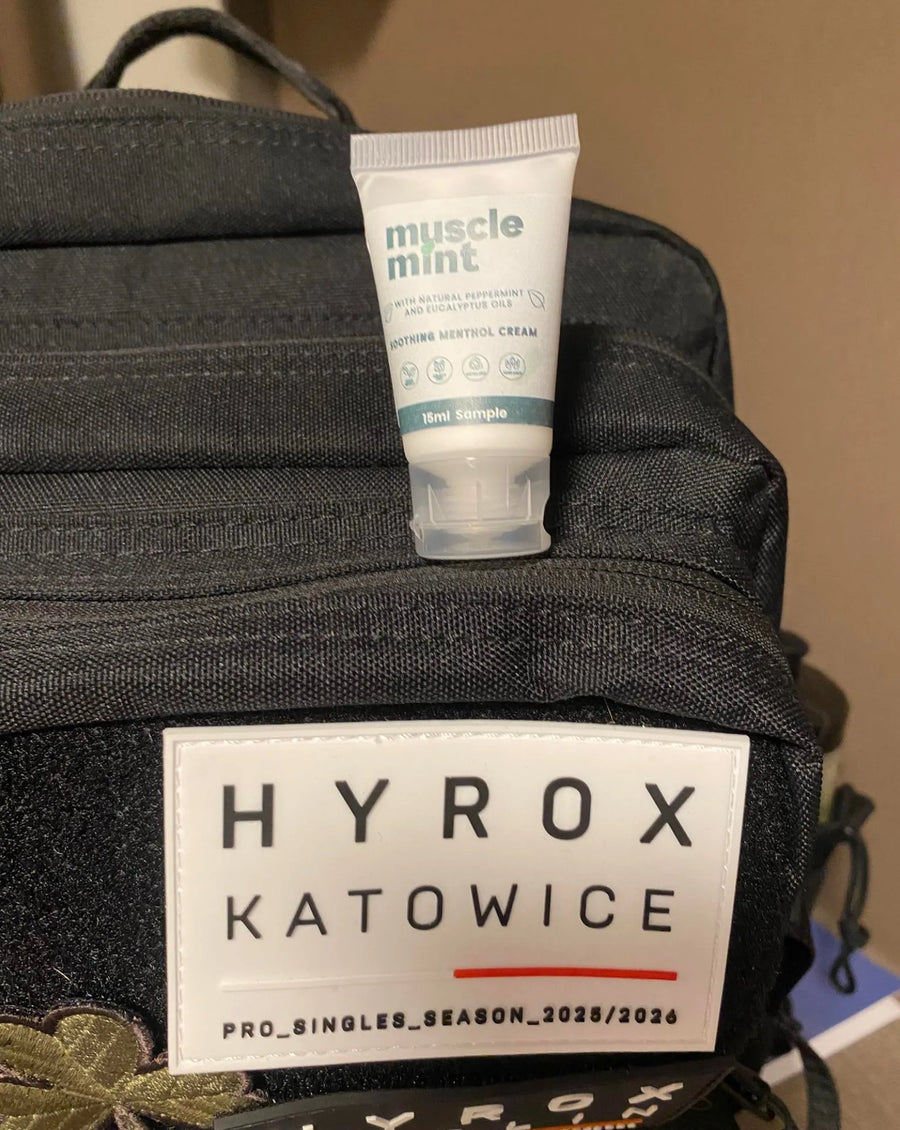 A travel size Muscle Mint bottle displayed on a HYROX Katowice-branded travel bag at an event in Poland.